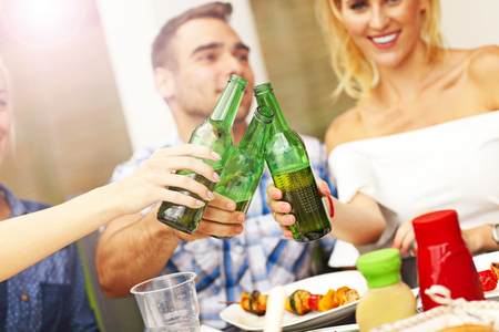 Picture presenting group of friends with beer during bbq partyの写真素材