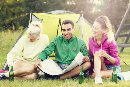 Picture of group of friends camping in forest and looking at mapの写真素材