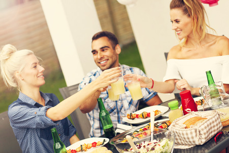 Picture presenting group of friends having barbecue partyの写真素材