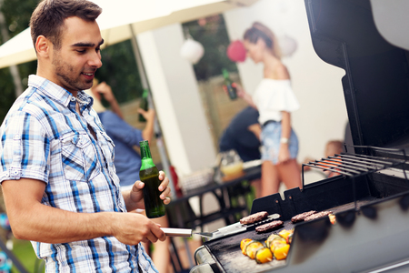Picture of young man grilling foodの写真素材