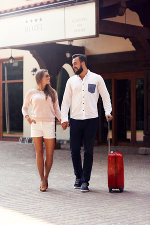 Picture of young couple walking out of hotelの写真素材