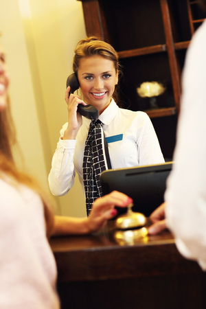 Picture of pretty receptionist answering phoneの写真素材