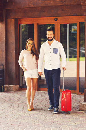 Picture of young couple walking out of hotelの写真素材