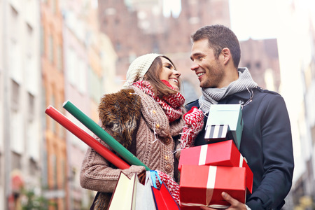 Picture showing young couple doing Christmas shopping in the cityの写真素材