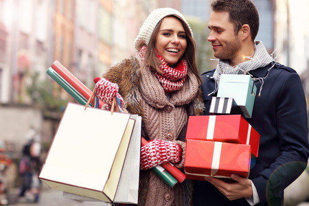 Picture showing young couple doing Christmas shopping in the cityの写真素材