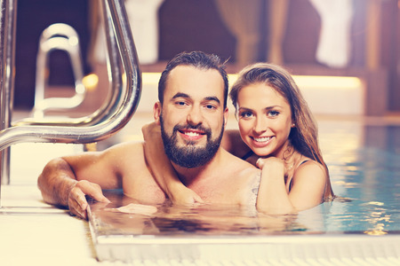 Picture of happy couple relaxing in pool spaの写真素材