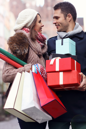 Picture showing young couple doing Christmas shopping in the cityの写真素材
