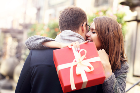 Picture of woman with present giving hug to her manの写真素材