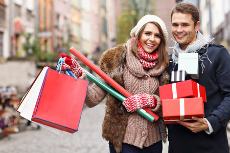 Picture showing young couple doing Christmas shopping in the cityの写真素材