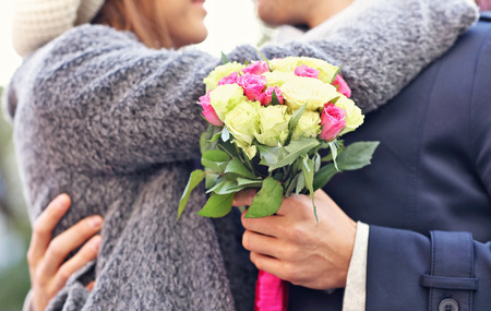 Midsection of young couple kissing in the parkの写真素材