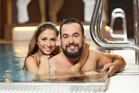 Picture of happy couple relaxing in pool spaの写真素材