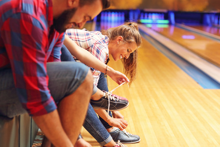 Picture showing friends putting on bowling shoesの写真素材