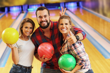 Picture showing friends playing bowlingの写真素材