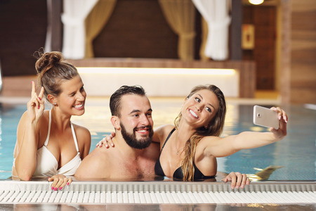 Picture showing happy group of friends relaxing in pool spaの写真素材