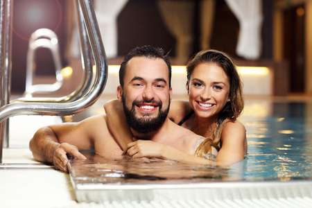 Picture of happy couple relaxing in pool spaの写真素材
