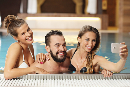 Picture showing happy group of friends relaxing in pool spaの写真素材