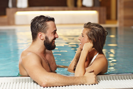 Picture of happy couple relaxing in pool spaの写真素材