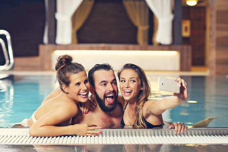 Picture showing happy group of friends relaxing in pool spaの写真素材