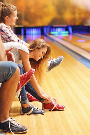 Picture showing friends putting on bowling shoesの写真素材