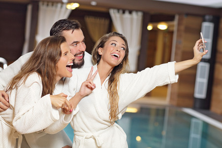 Picture showing happy group of friends relaxing in pool spaの写真素材