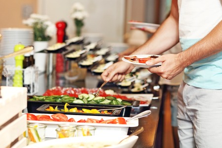 Midsection of man at breakfast buffet in hotelの写真素材