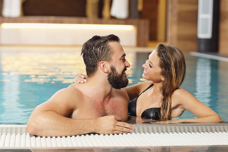 Picture of happy couple relaxing in pool spaの写真素材