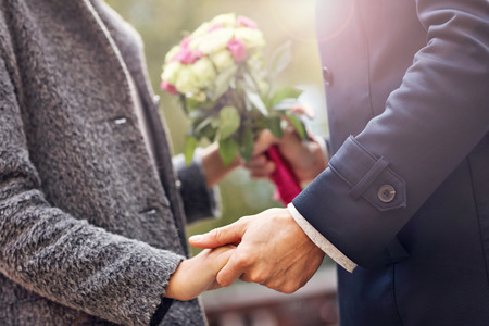 Midsection of young couple with flowers