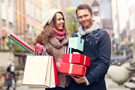 Picture showing young couple doing Christmas shopping in the cityの写真素材