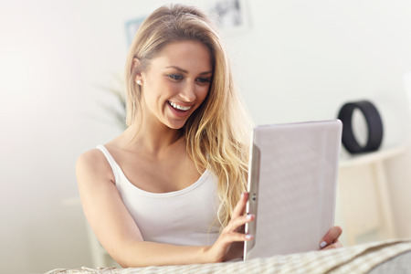 Picture showing happy woman with tablet on sofaの写真素材