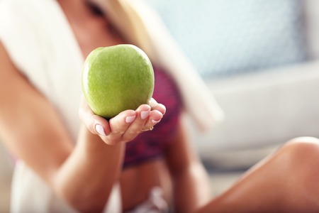 Fit woman eating carrot at homeの写真素材