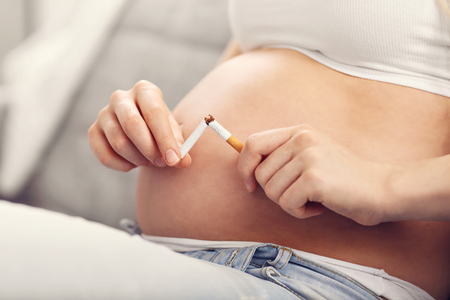 Close up of pregnant woman breaking cigaretteの写真素材