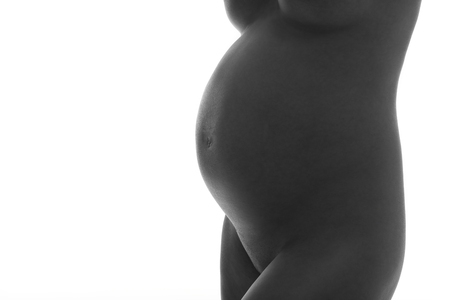 Pregnant woman posing over white backgroundの写真素材