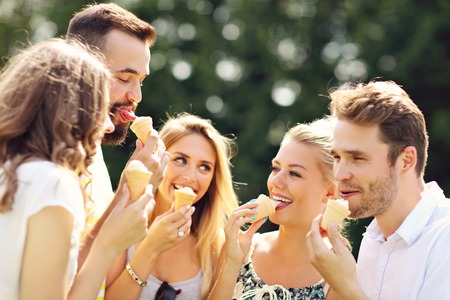 Group of friends eating ice-cream outdoorsの写真素材