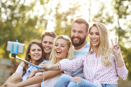 Happy group of friends taking selfie outdoorsの写真素材
