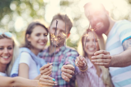 Group of friends having fun with sparklersの写真素材