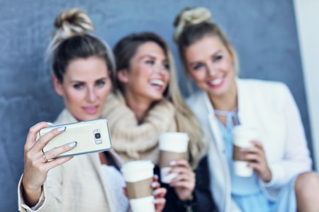 Happy group of friends taking selfie outside in autumn seasonの写真素材