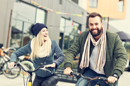 Young couple riding bikes and having fun in the cityの写真素材