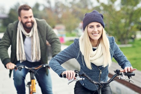 Young couple riding bikes and having fun in the cityの写真素材