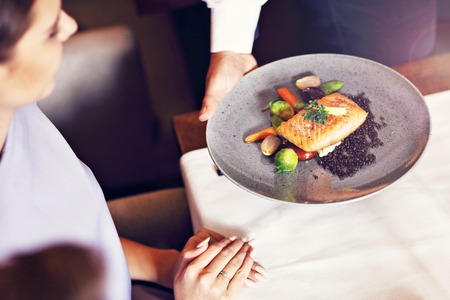 Couple eating romantic Dinner in a gourmet restaurant drinking wine and eatingの写真素材