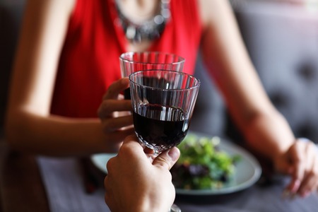 Couple eating romantic Dinner in a gourmet restaurant drinking wine and holding handsの写真素材