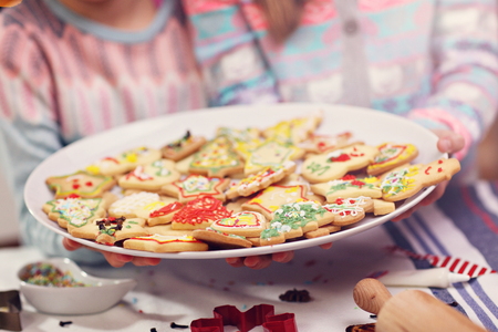 Happy little sisters preparing Christmas biscuitsの写真素材