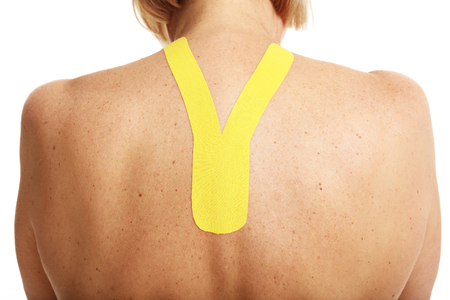Picture showing special physio tape put on injured back over white backgroundの写真素材