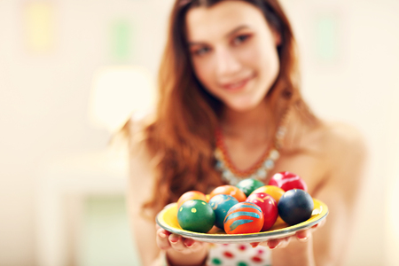 Attractive woman painting Easter eggs at homeの写真素材