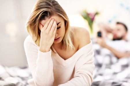 Adult attractive couple in bed having problemの写真素材