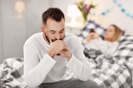 Adult attractive couple in bed having problemの写真素材