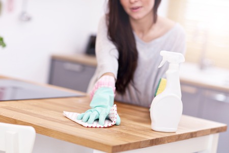 Beautiful young woman cleaning the kitchenの写真素材