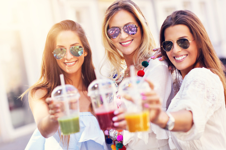 Happy girl friends hanging out in the city in summerの写真素材