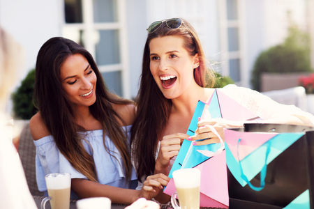 Happy girl friends in cafe during summer timeの写真素材