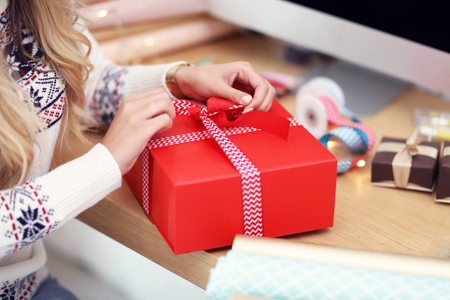 Adult woman at home wrapping Christmas presentsの写真素材