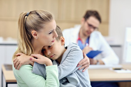 Little boy with mother in clinic having a checkup with pediatricianの写真素材